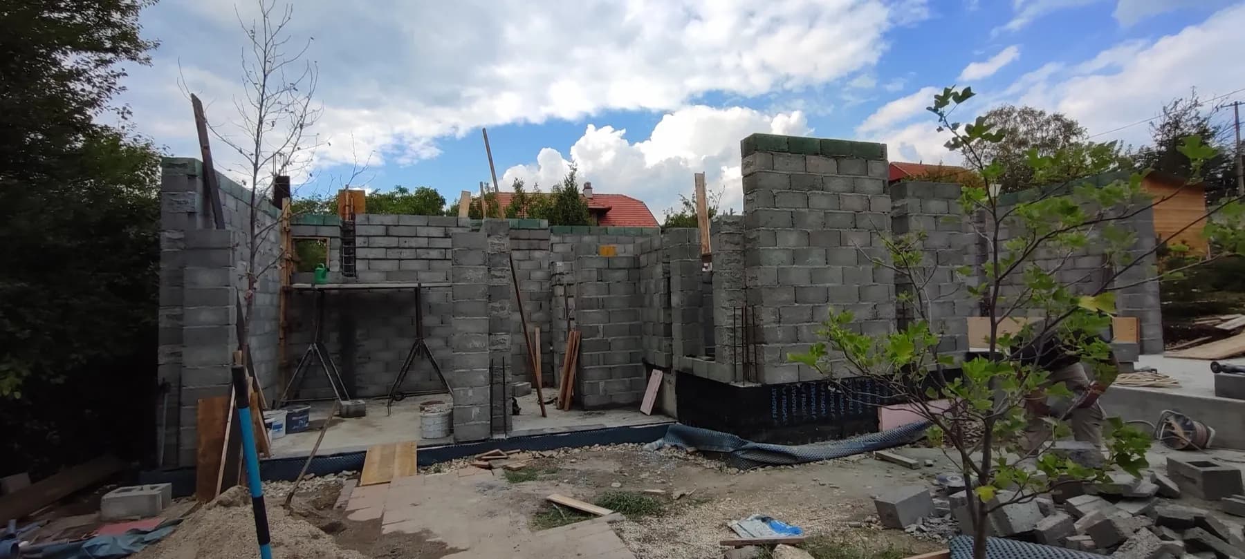 Zidovi prizemlja od sivih blokova, sa daskama i materijalom na gradilištu