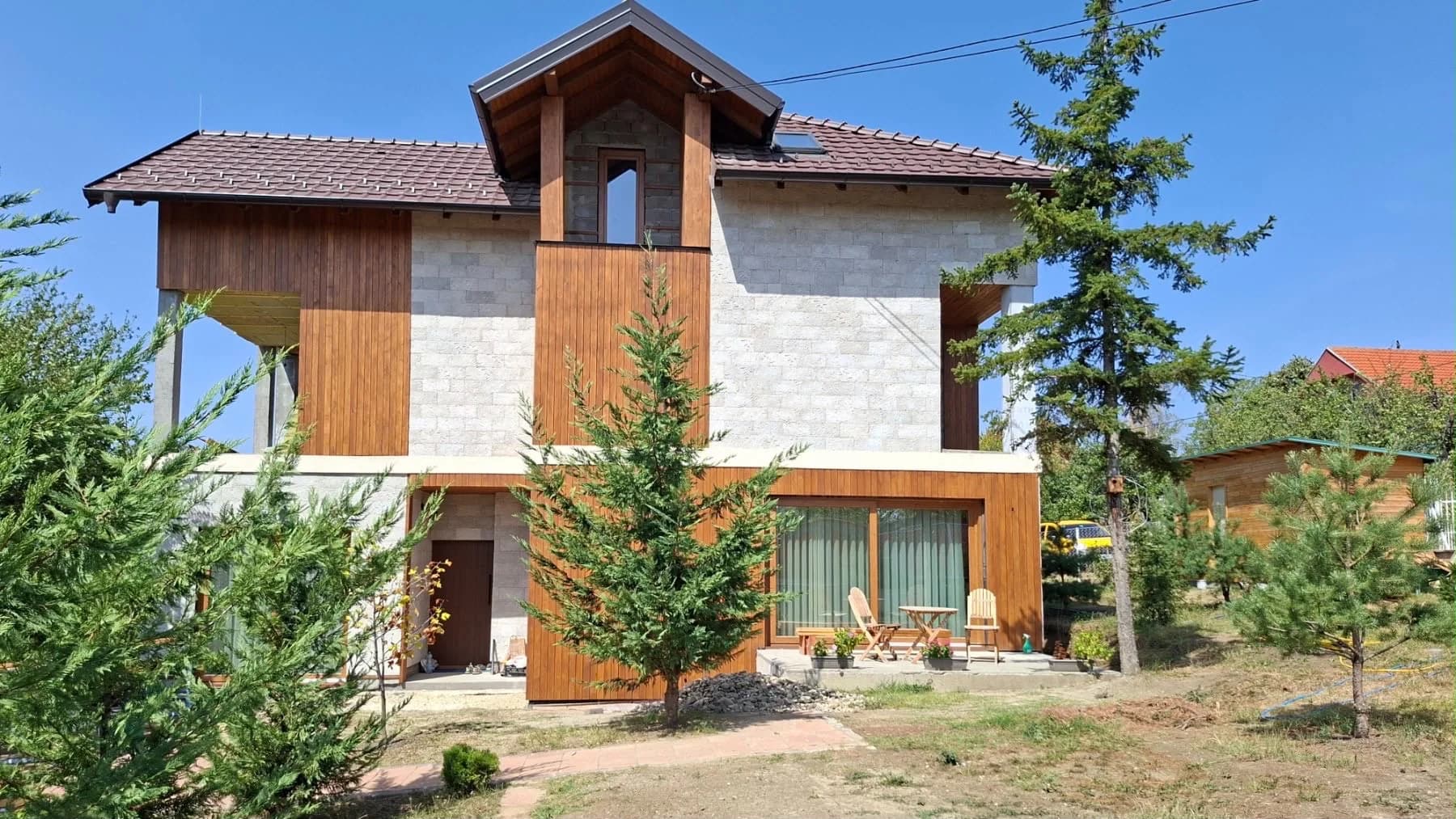 Dvospratna kuća sa svetlim blokovima, drvenim oblogama i vrtom